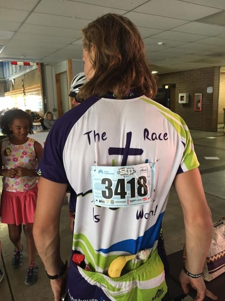 Back of cycling jersey reading 'The Race Is Won' with race bib 3418